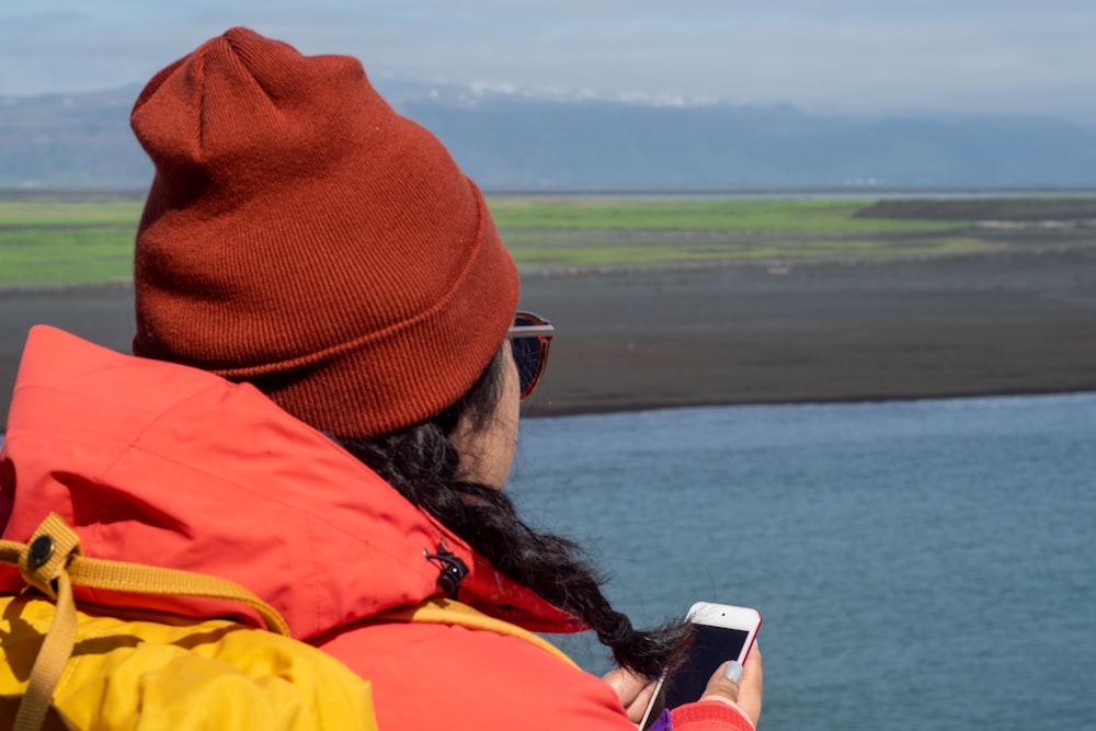 a person with a cell phone looking out over a body of water