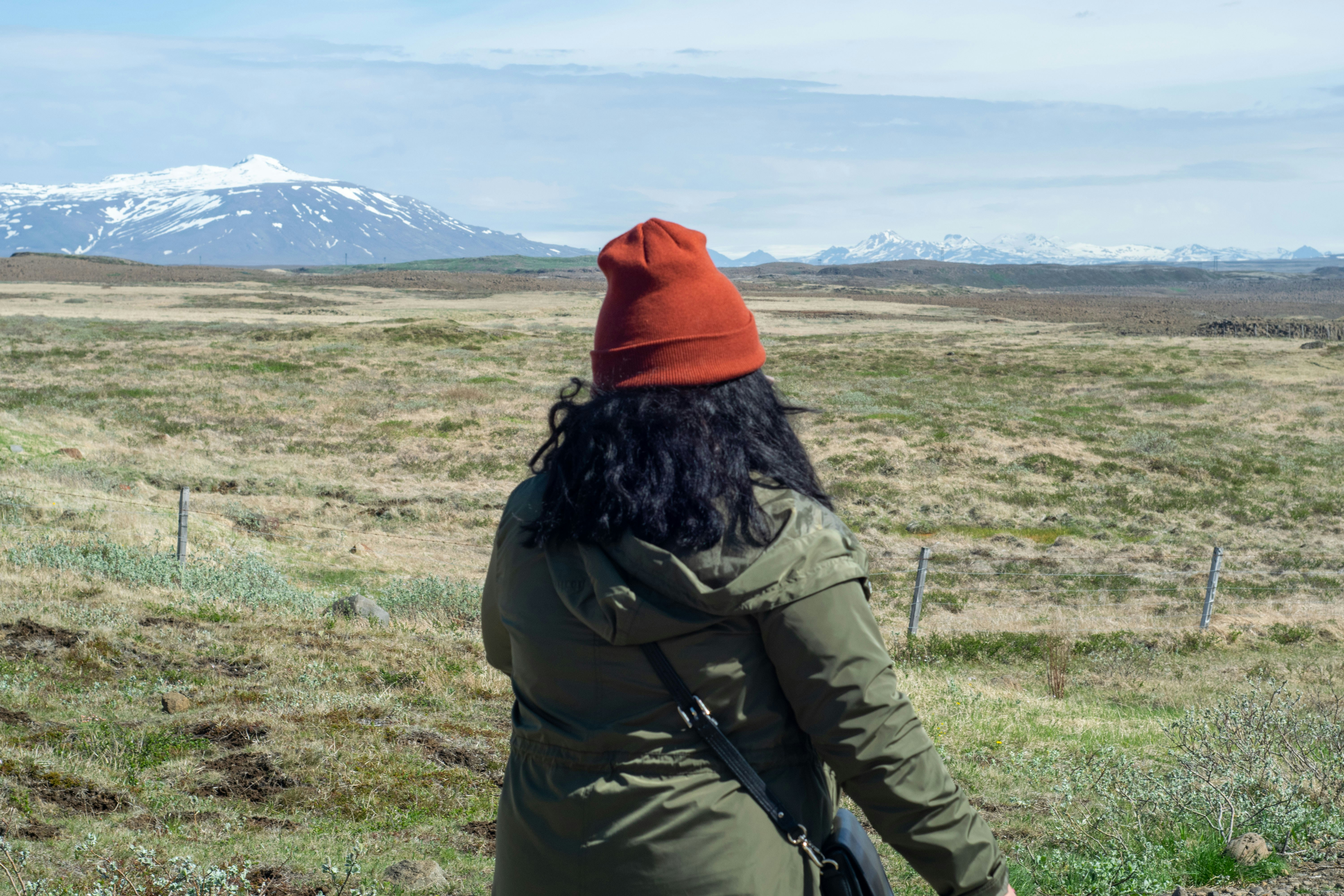 a woman in a red hat is walking in a field