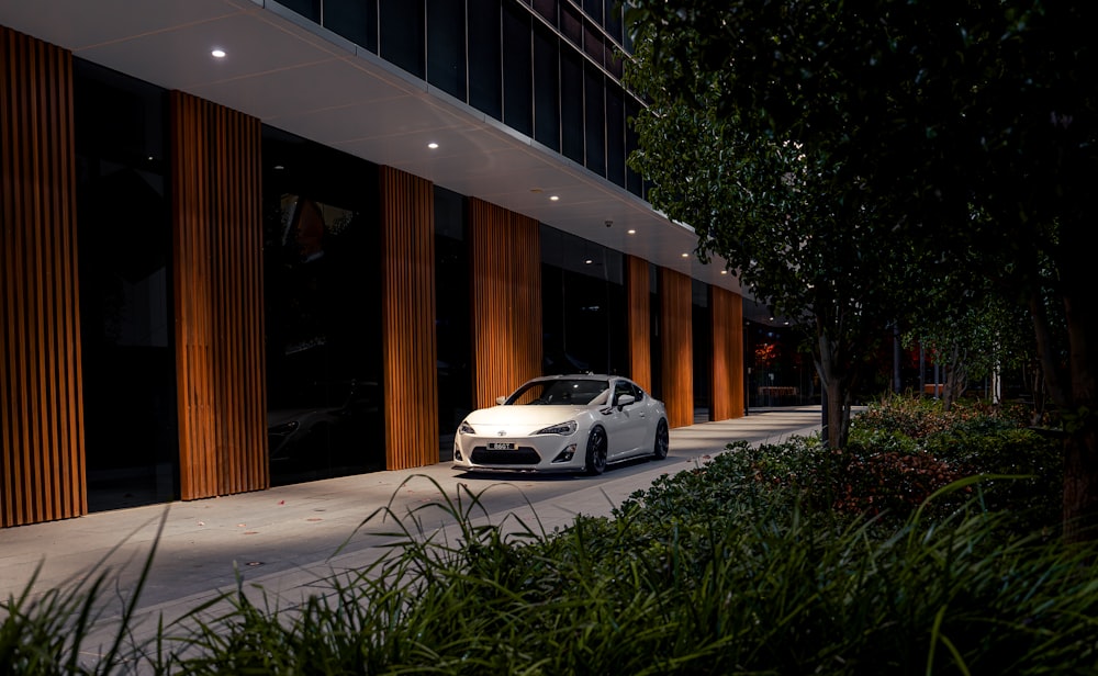 a white sports car parked in front of a building