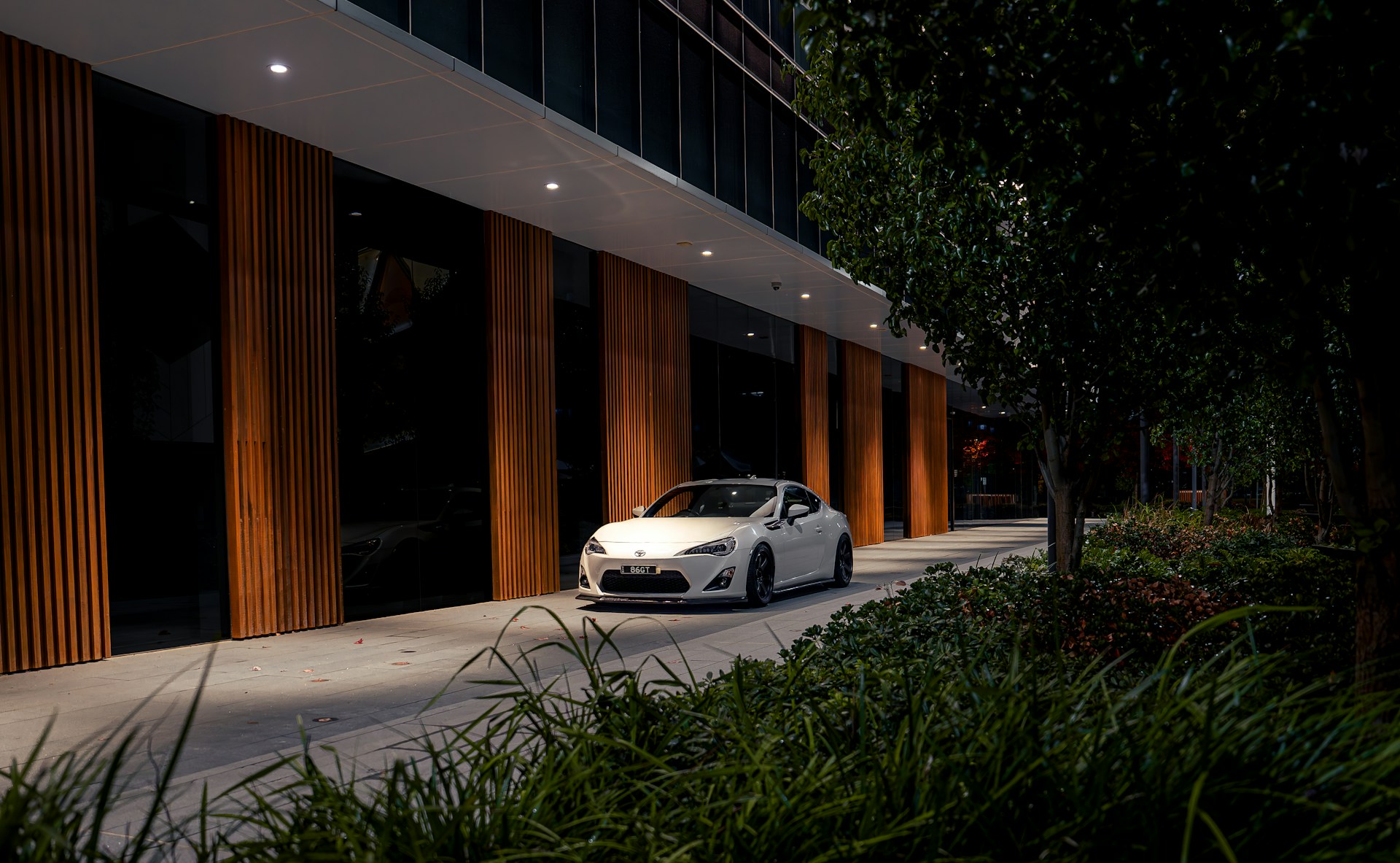 a white sports car parked in front of a building