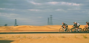 Group of cyclists riding through rugged desert trails near Caldera.