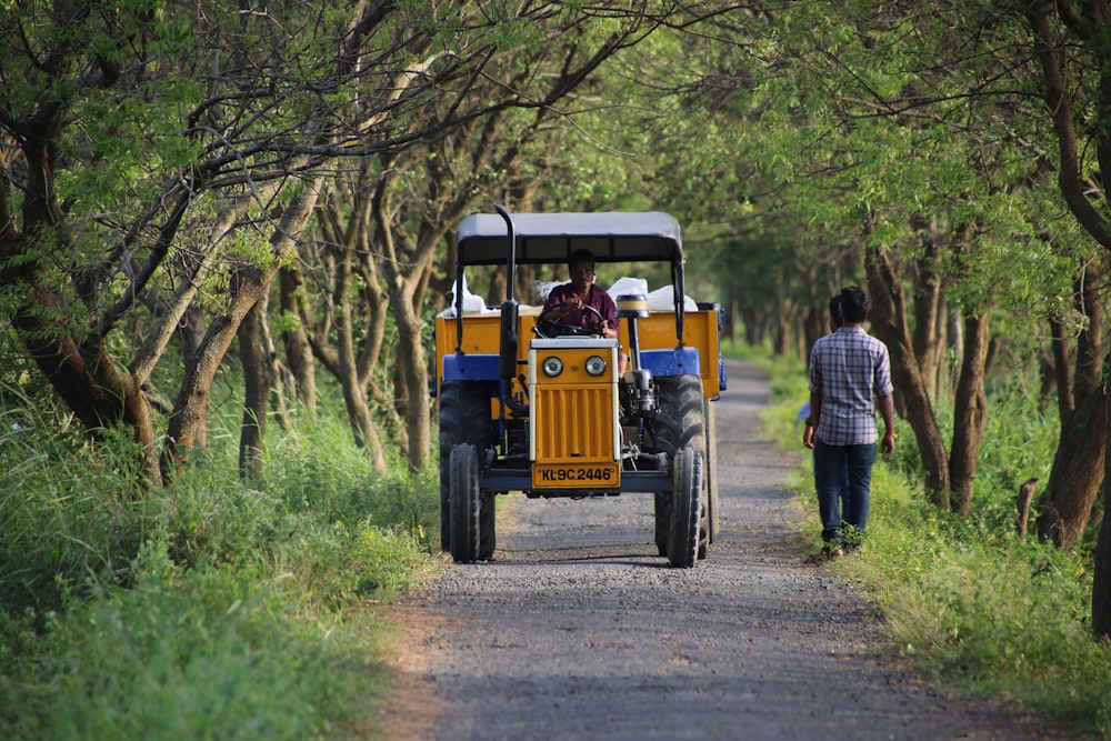a man driving a tractor down a dirt road