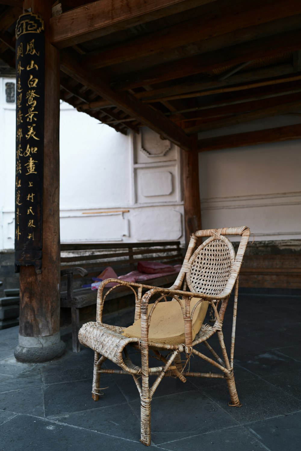 a wicker chair sitting under a wooden structure