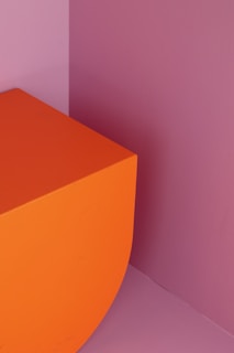 An abstract graphic artwork blending sharp lines with warm orange highlights.