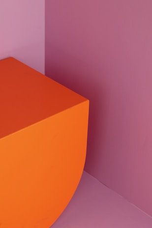 An abstract graphic artwork blending sharp lines with warm orange highlights.