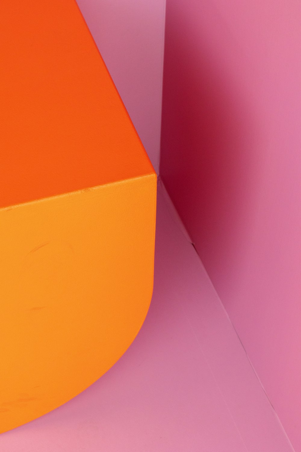 an orange box sitting on top of a pink surface