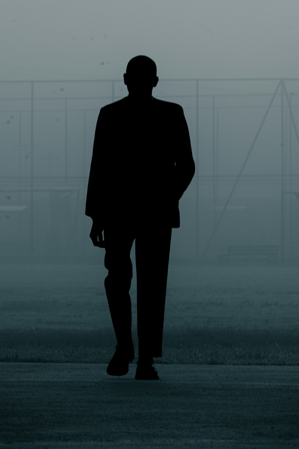 a silhouette of a man in a suit and hat