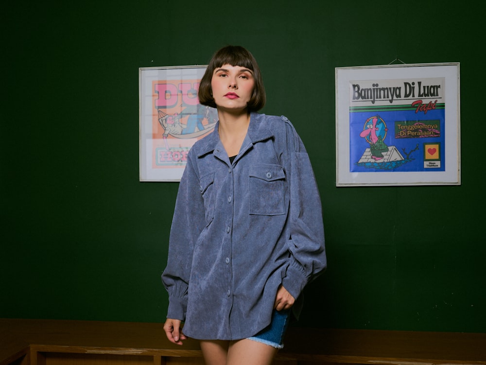 a woman standing in front of a green wall