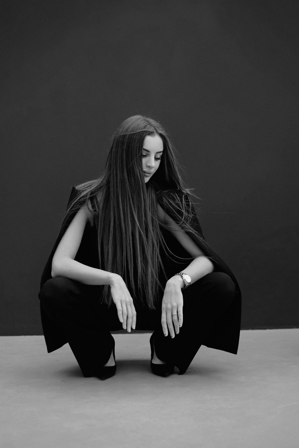 a woman with long hair sitting on the ground