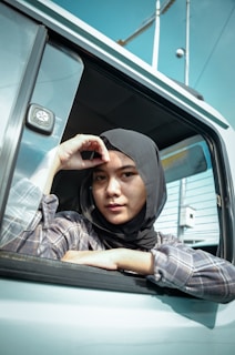 A serene street scene featuring a woman in a chic, modern hijab outfit.