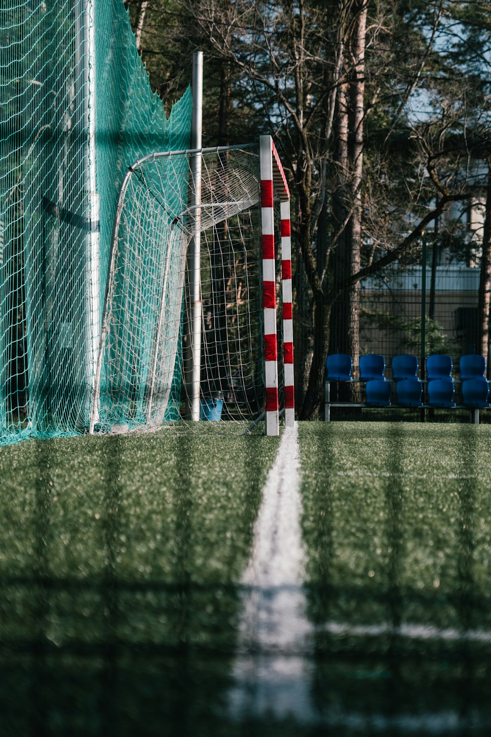 a soccer field with a goal and a red and white marker