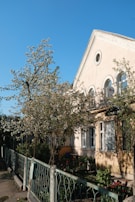 A residential home with crystal-clear windows shining in the morning light, surrounded by blooming flowers.