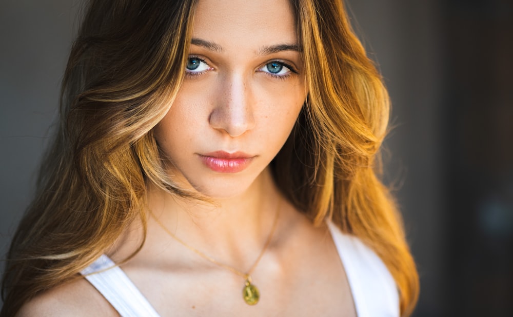 a beautiful young woman with blue eyes posing for a picture