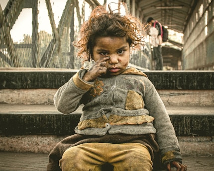 a little girl sitting on the steps of a bridge