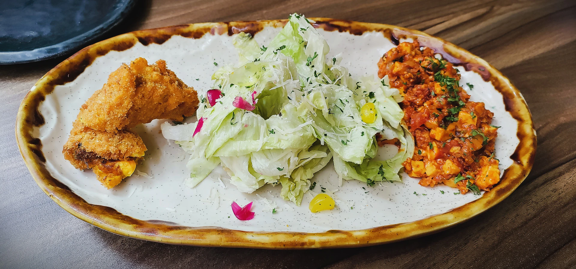 A close-up of a vibrant plate featuring golden fried ginger chicken with a side of colorful Asian-style vegetables.