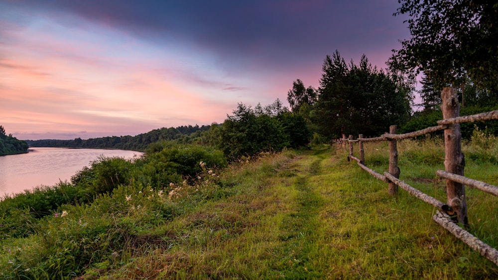 a wooden fence next to a body of water