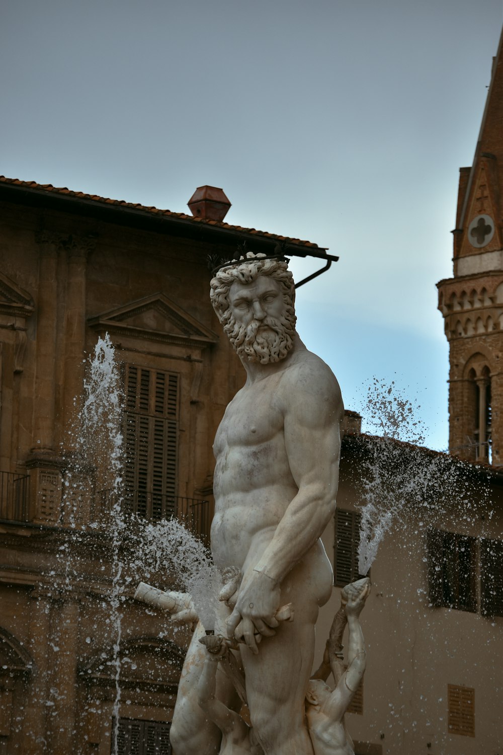 Una estatua de un hombre de pie junto a una fuente