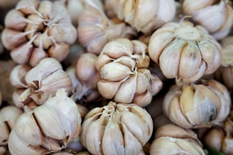 Close-up of several garlic bulbs clustered together, showcasing their papery skins and tightly packed cloves.