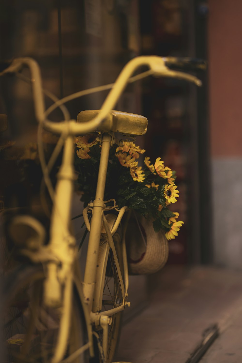 a yellow bicycle with a basket full of flowers