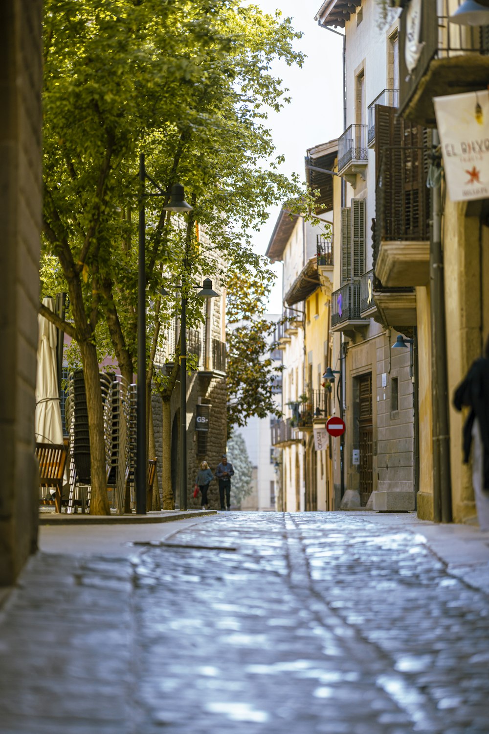 a person walking down a street next to tall buildings