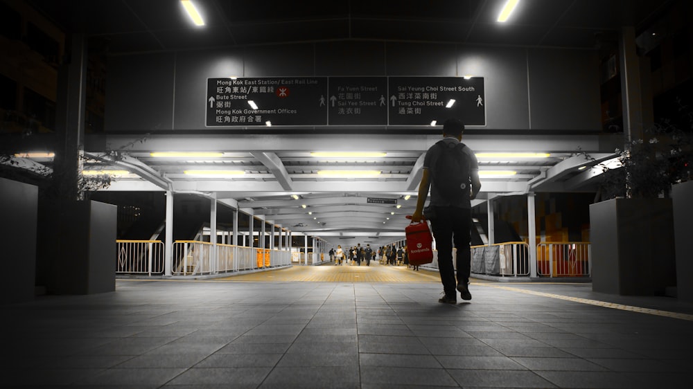 a man with a red bag is walking through an airport