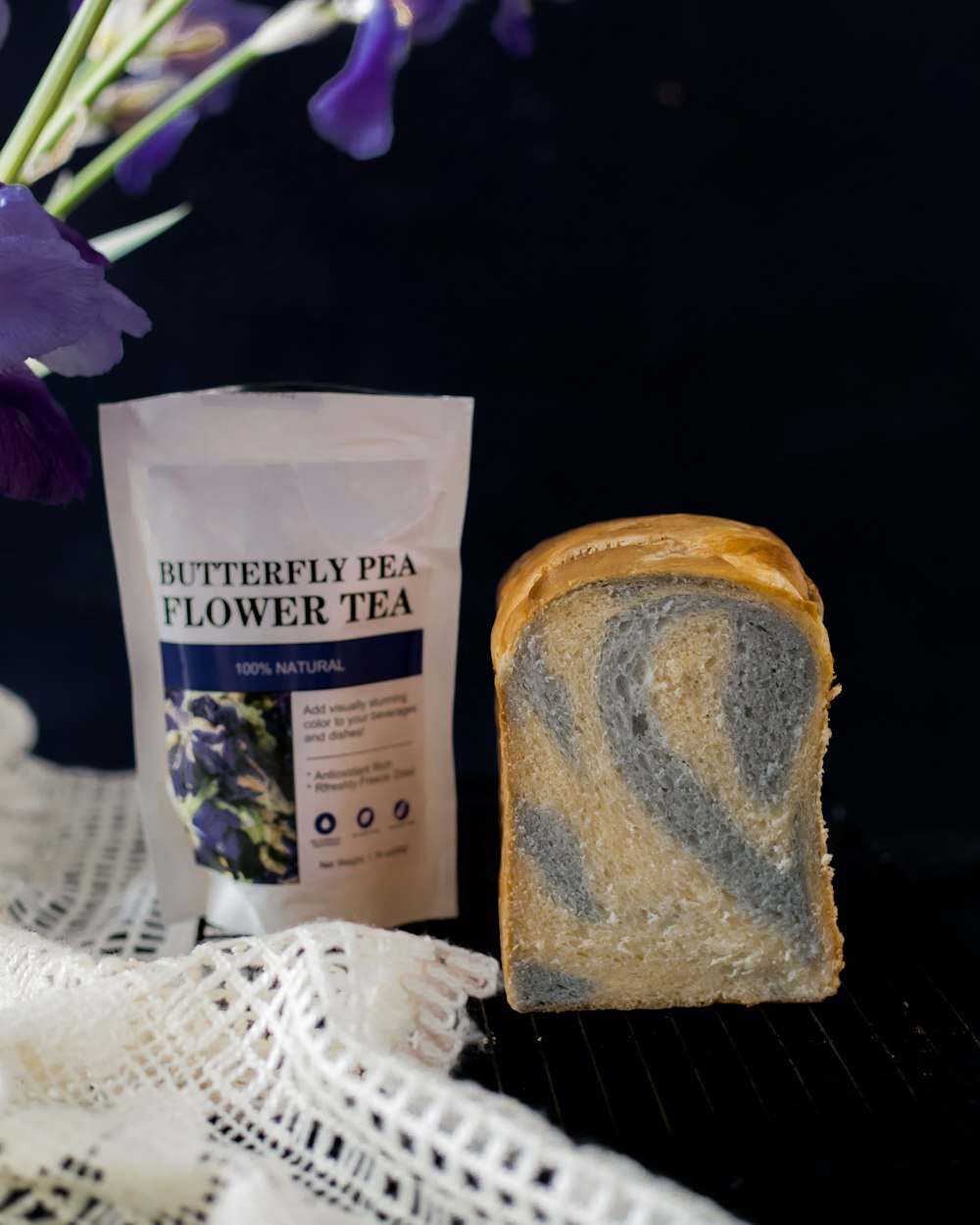 a piece of bread sitting next to a bag of tea