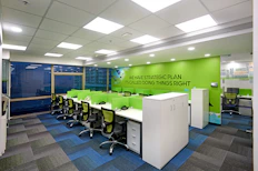 A sleek, modern office workspace with dark blue and black tones, illuminated by green and gold accents.