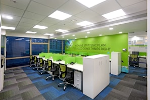 Collaborative workspace with sleek gray furniture and vibrant green details.