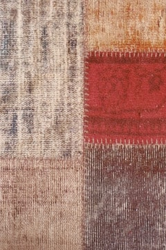 Detailed shot of repaired carpet edges with traditional stitching.