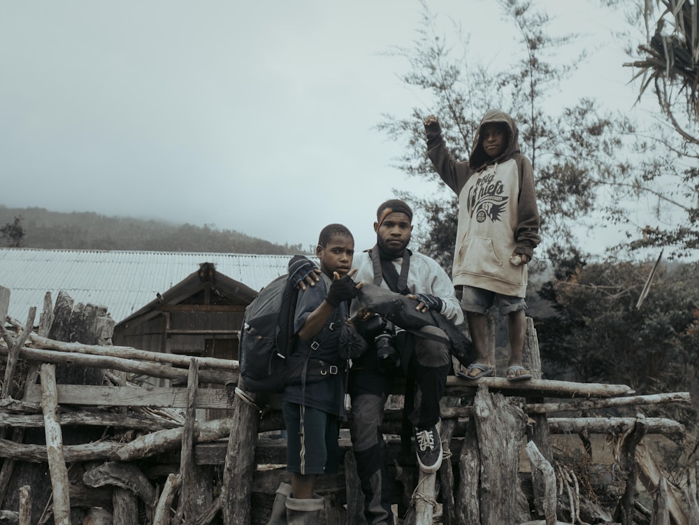 a group of people standing on top of a wooden fence