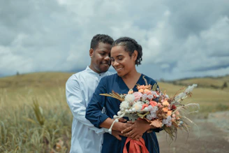 a man and a woman holding a bouquet of flowers