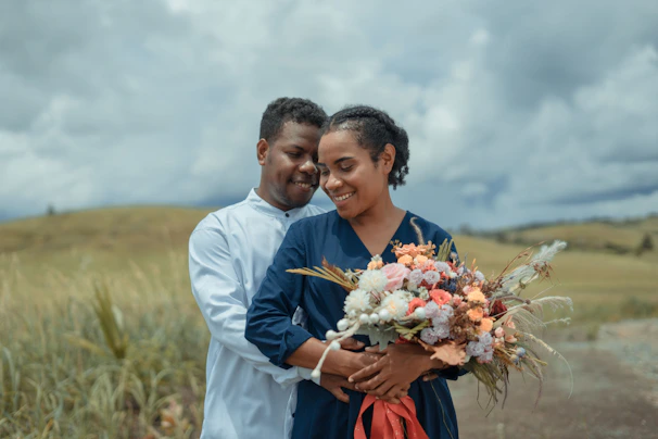 a man and a woman holding a bouquet of flowers