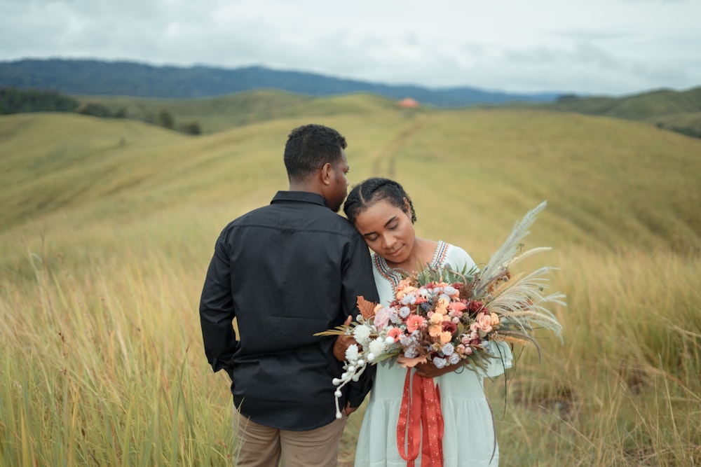 a man and a woman standing in a field