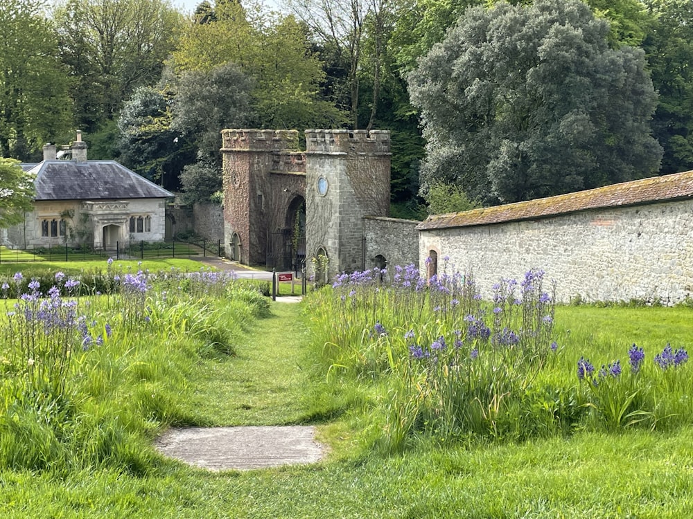 a stone building surrounded by lush green grass