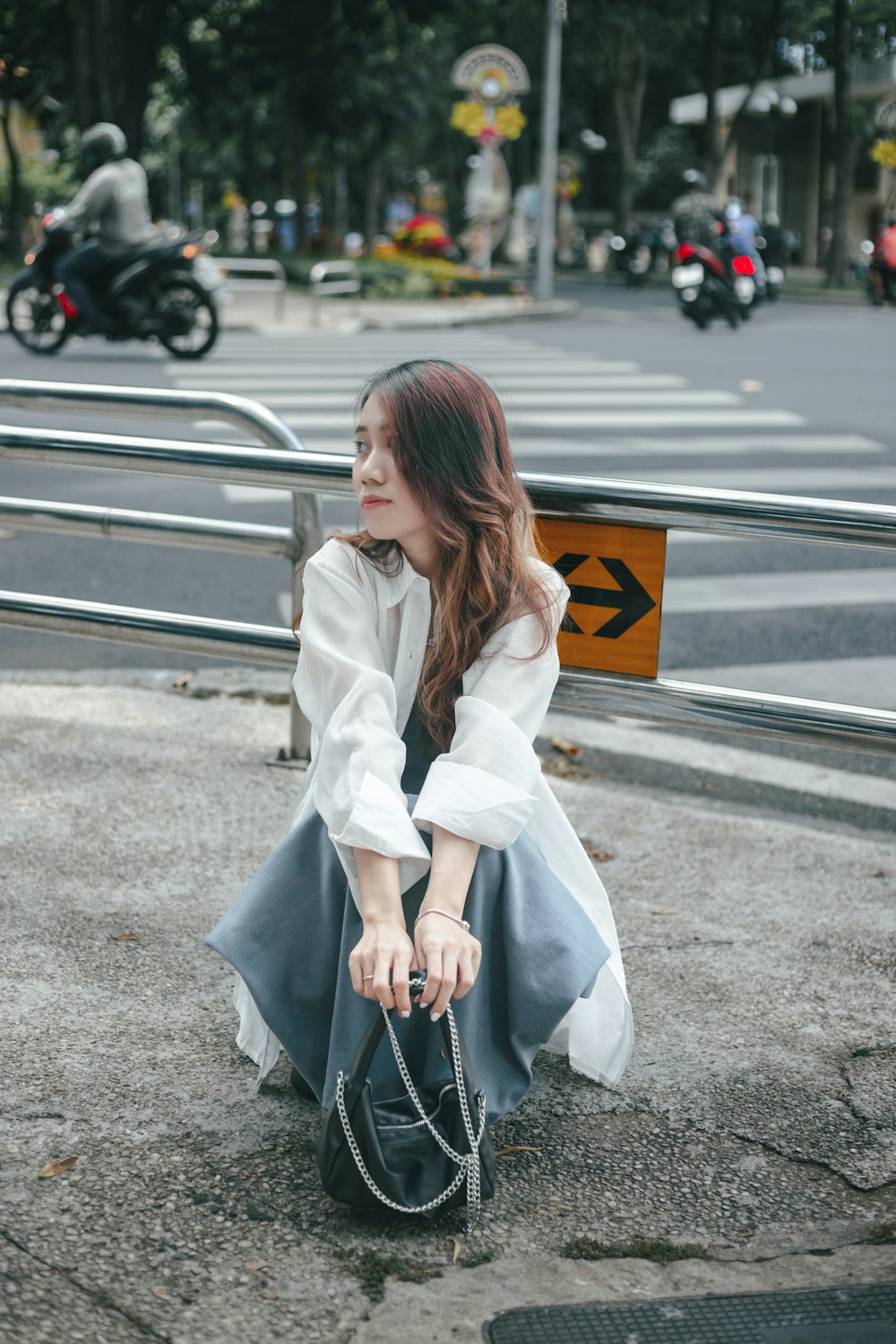 A woman sitting on the ground holding a purse photo – Free Woman Image on  Unsplash