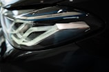 Close-up of a sleek car headlight featuring intricate design details and metallic accents. The headlight is part of a modern vehicle with a sophisticated lighting system, indicated by the 'BMW Laser' branding.