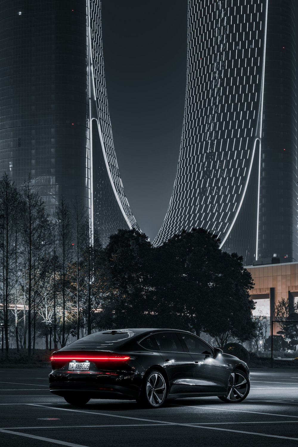 a black car parked in front of a tall building