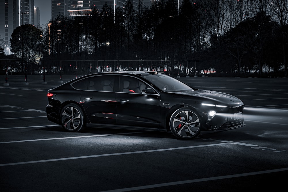 a black car parked in a parking lot at night