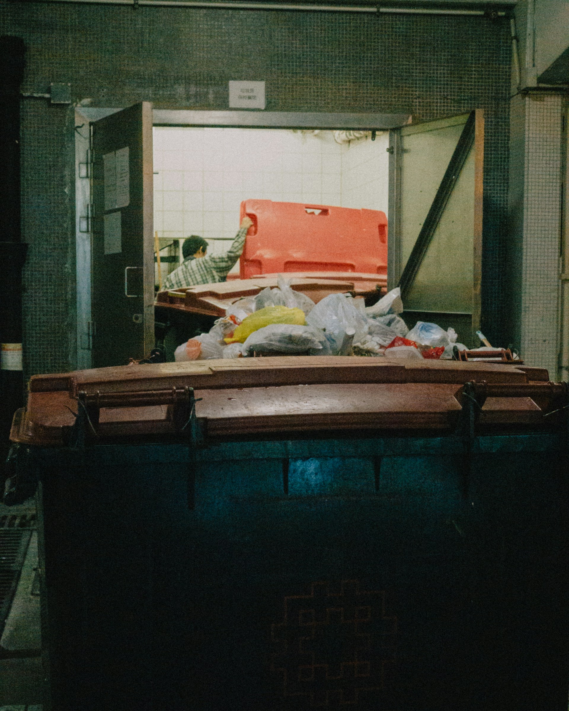 a man standing next to a pile of garbage