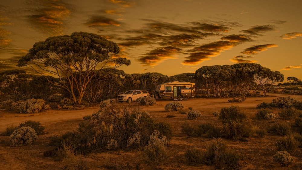 a couple of vehicles parked on a dirt road