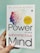 A hand is holding a book titled 'The Power of Your Subconscious Mind' by Dr. Joseph Murphy. The cover features a silhouette of a head with a colorful array of birds flying away from it, symbolizing thoughts or ideas. There is a yellow circle indicating 'Millions of Copies Sold.'