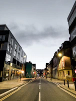 A wide shot of a desolate urban street at dusk, setting a somber, realistic tone.