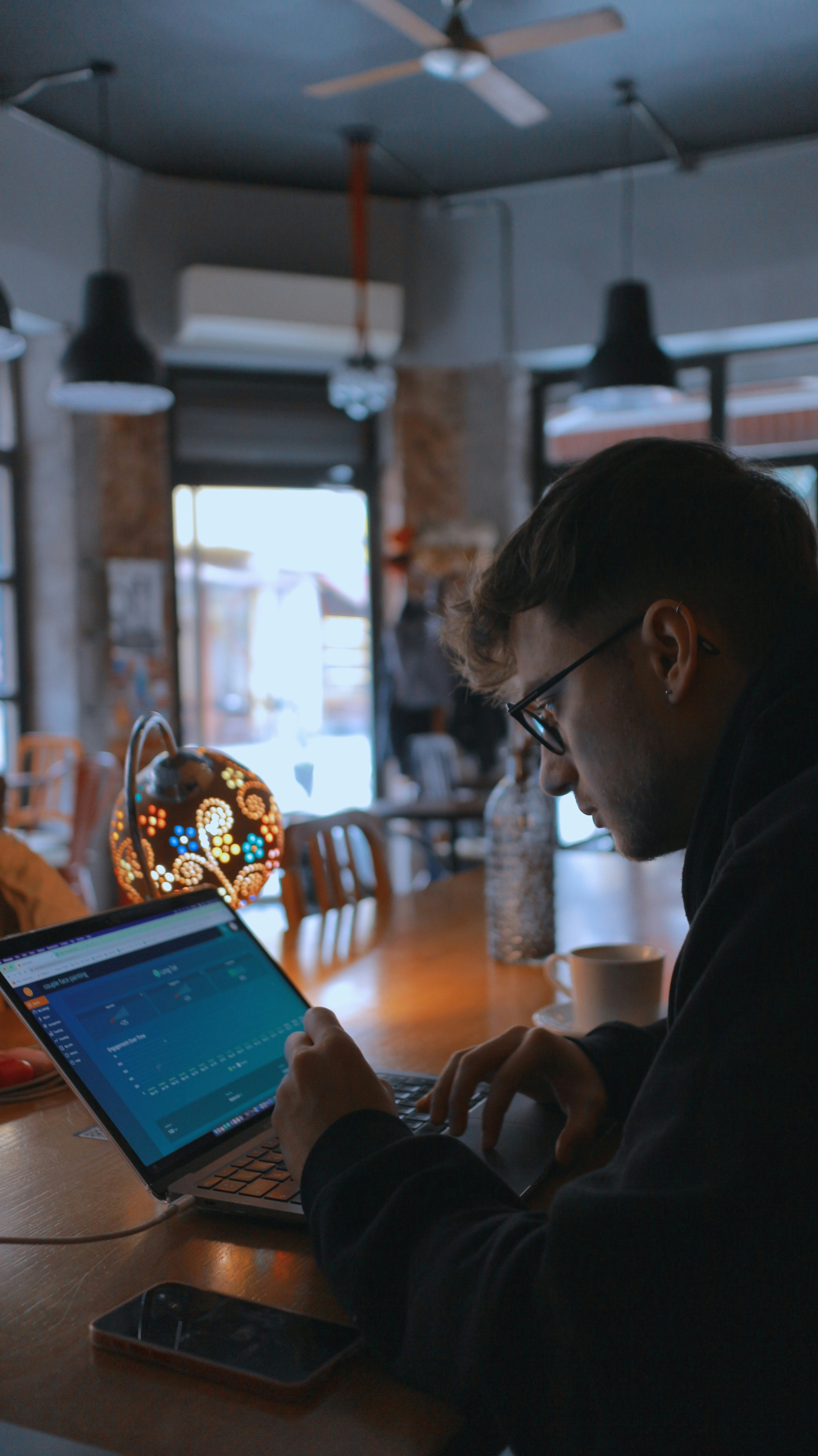 a man sitting at a table using a laptop computer