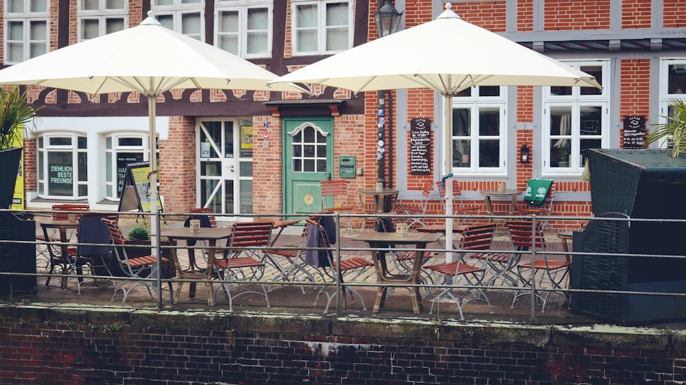 un groupe de tables avec des parasols à l’extérieur d’un bâtiment