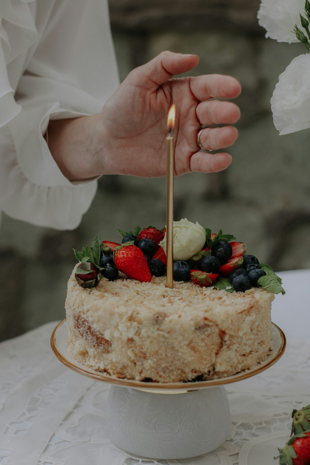 a person lighting a candle on top of a cake