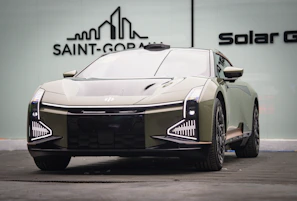 A sleek, futuristic car used for advanced driving lessons parked outside the driving school.