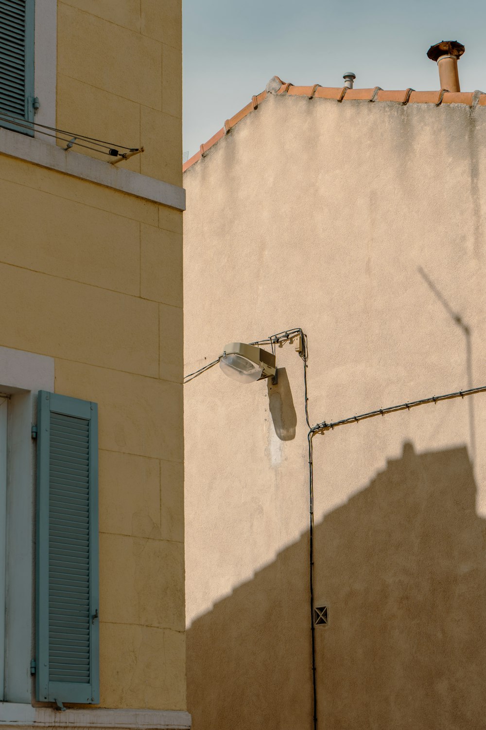 a street light next to a building with blue shutters