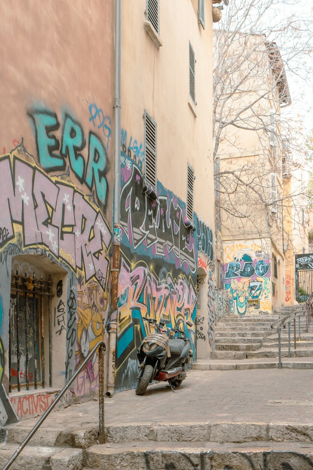 a motorcycle parked in front of a building covered in graffiti