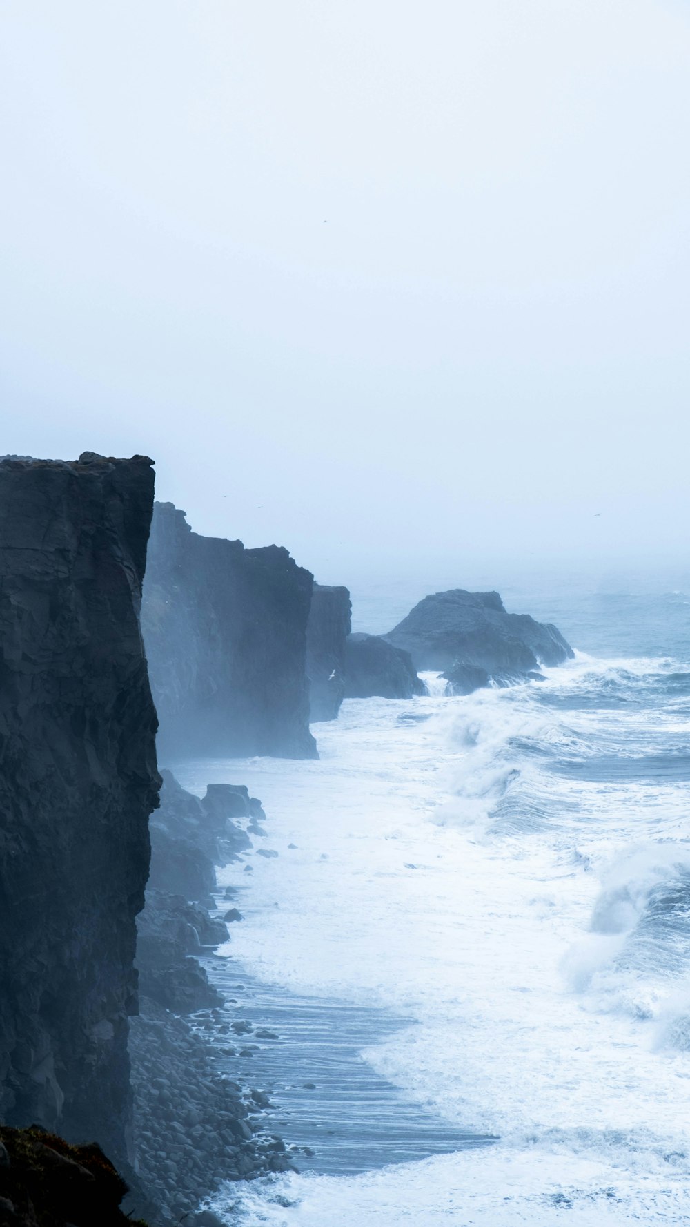 a person standing on a cliff overlooking the ocean