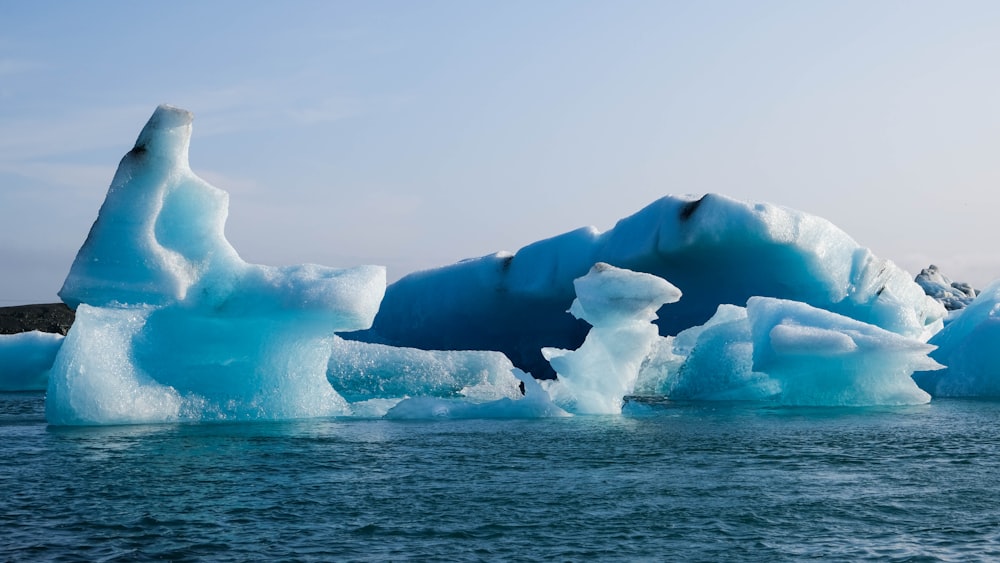 a group of icebergs floating on top of a body of water